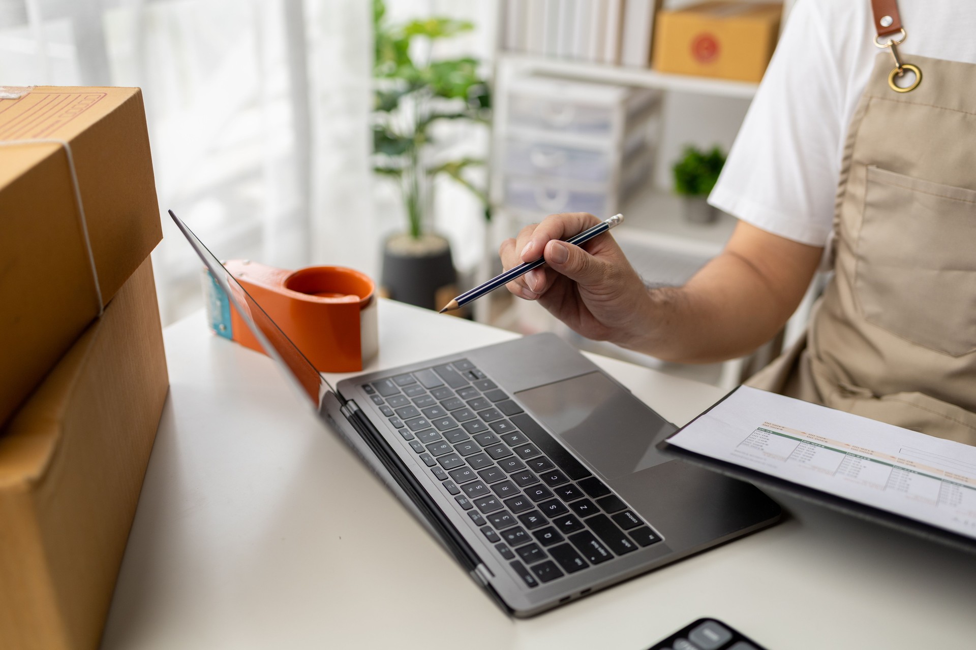 Hombre trabajando, propietario de la tienda en línea que verifica los pedidos de los sitios web en Internet para confirmar los pedidos con los clientes que los han pedido y los empaca para su entrega. Concepto de venta de productos online.