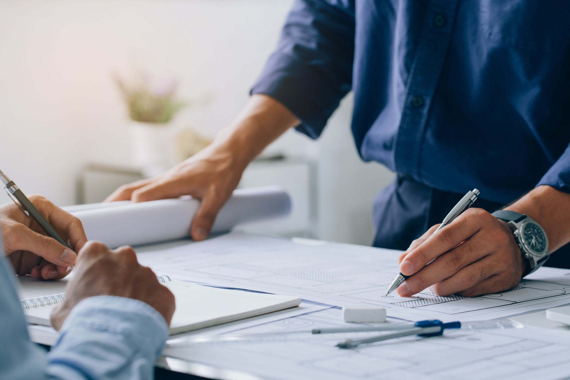 Dos arquitectos discutiendo un proyecto y trabajando en el plano en el sitio de construcción en el escritorio de la oficina, concepto arquitectónico y de ingeniería.